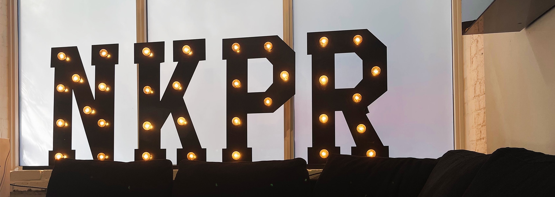 Light up NKPR logo sign on ledge.